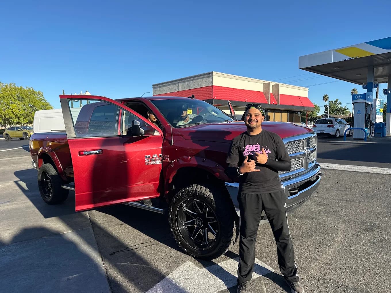 BubbleBee crew member hand washing a lifted red Ram truck in Citrus Heights
