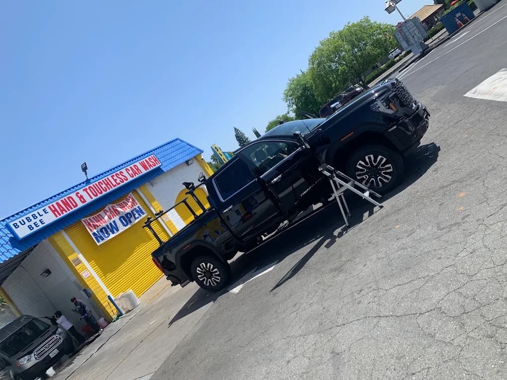 A customer's lifted GMC truck outside the BubbleBee hand and touchless car wash in Citrus Heights